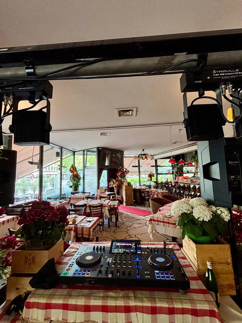 DJ decks between flowers and checked tablecloths inside Francucci, set up for Francucci Friday