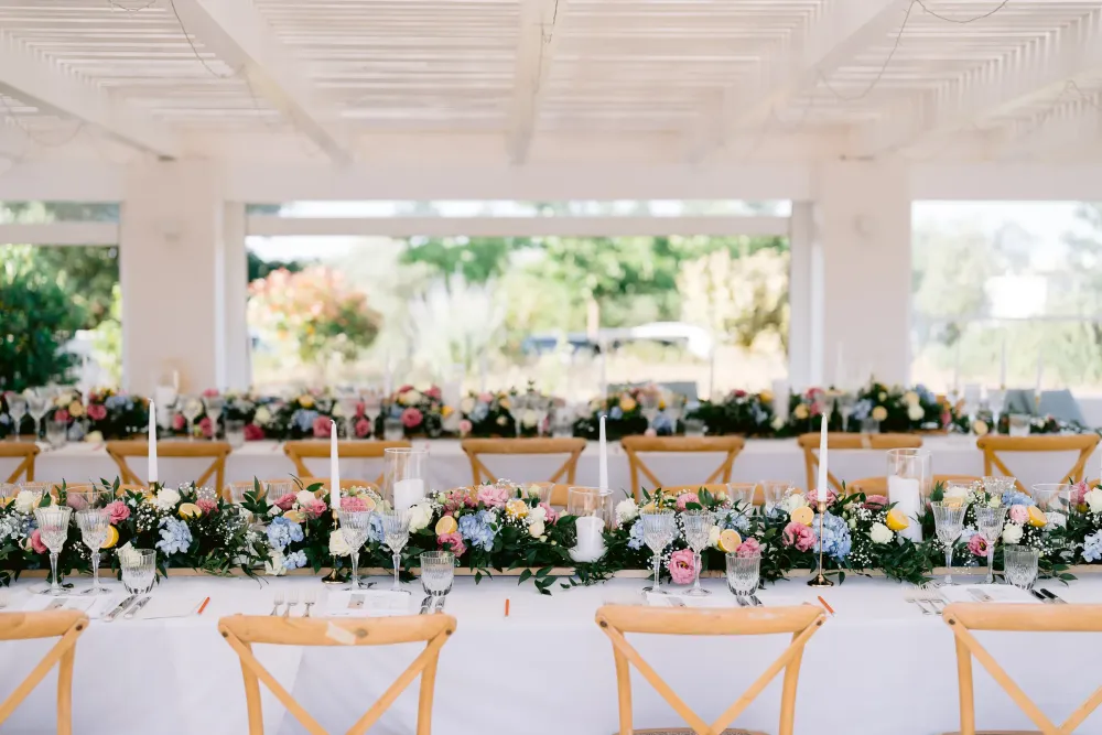 Lange gedeckte Hochzeitstafel von Romario Maison unter einer weißen Pergola im Valle d’Itria